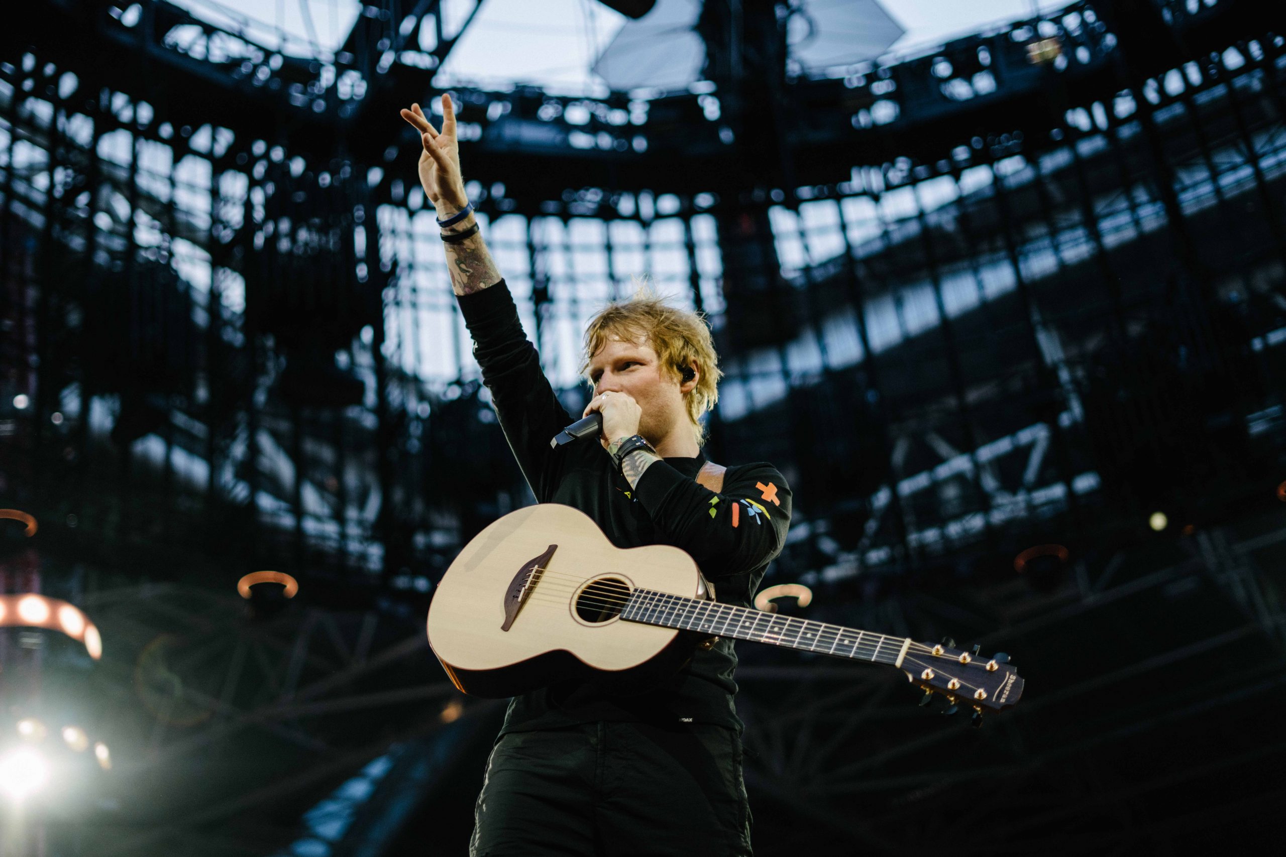 Ed Sheeran makes a peace sign during a performance