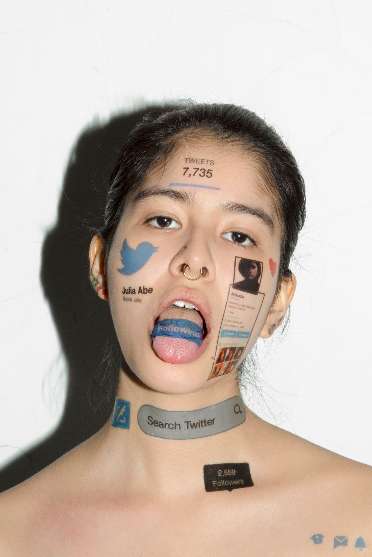 A woman's face with social media tattoos across it